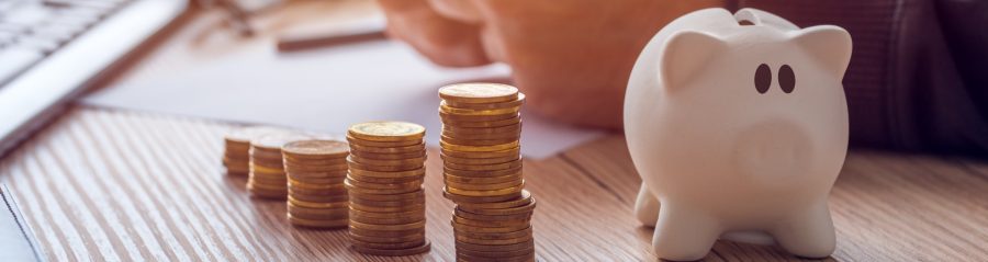 Piggy bank and piles of coins on a desk