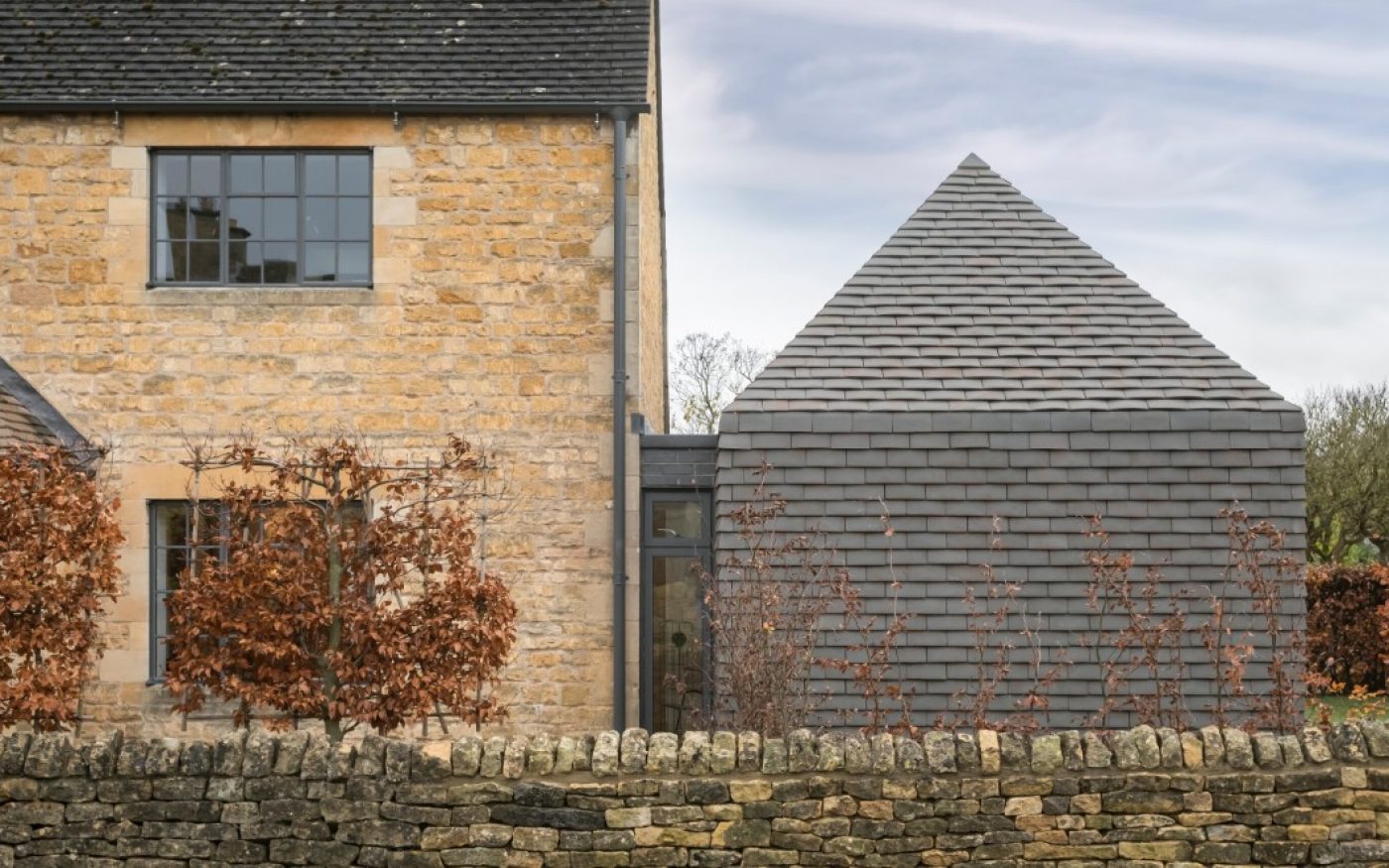 Traditional Cotswolds cottage with modern vertical tiled extension on side