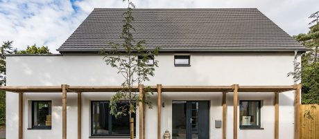 White modern house with wood beam shelter outside