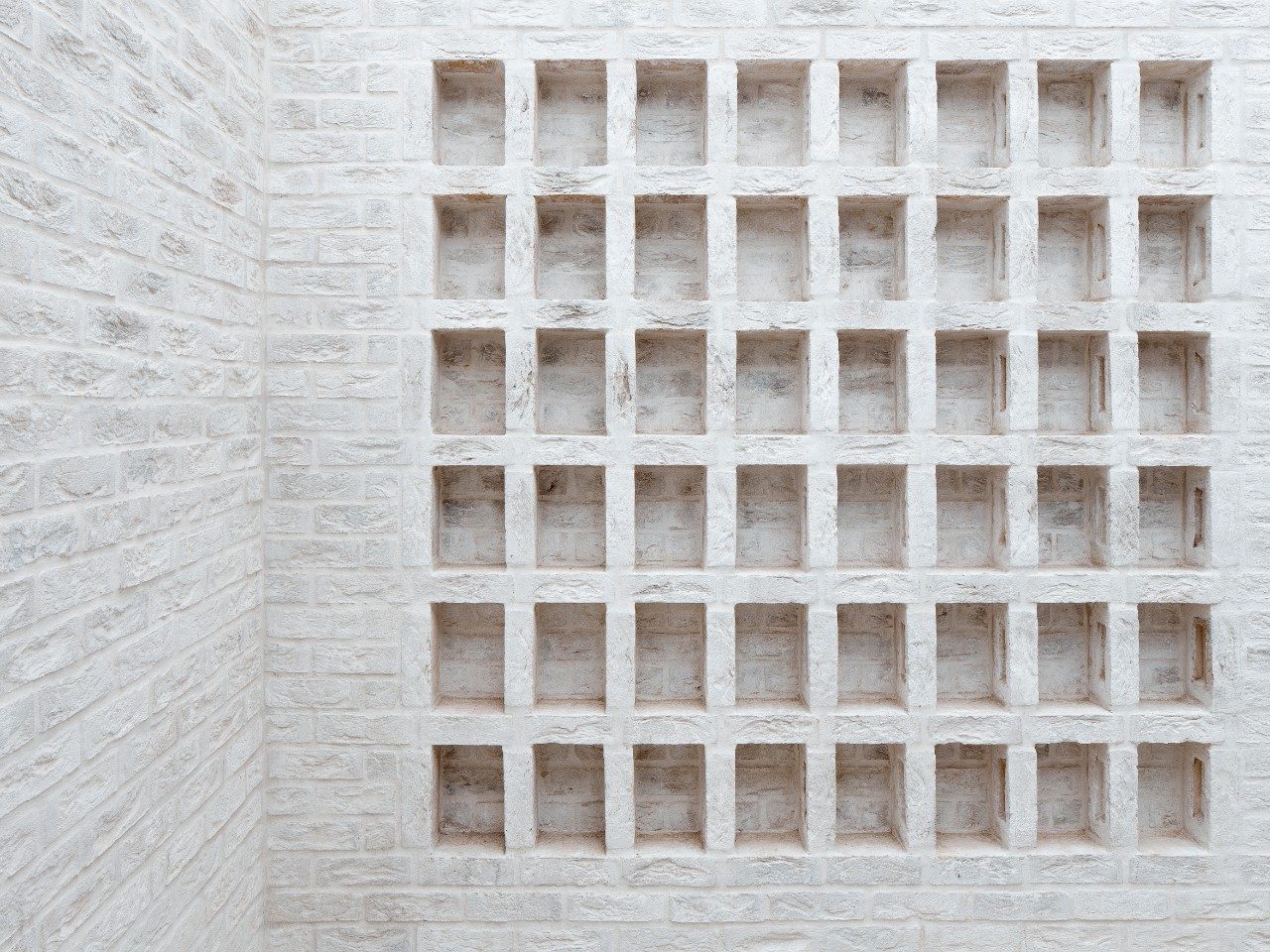 Alcoves in white brick wall of courtyard garden