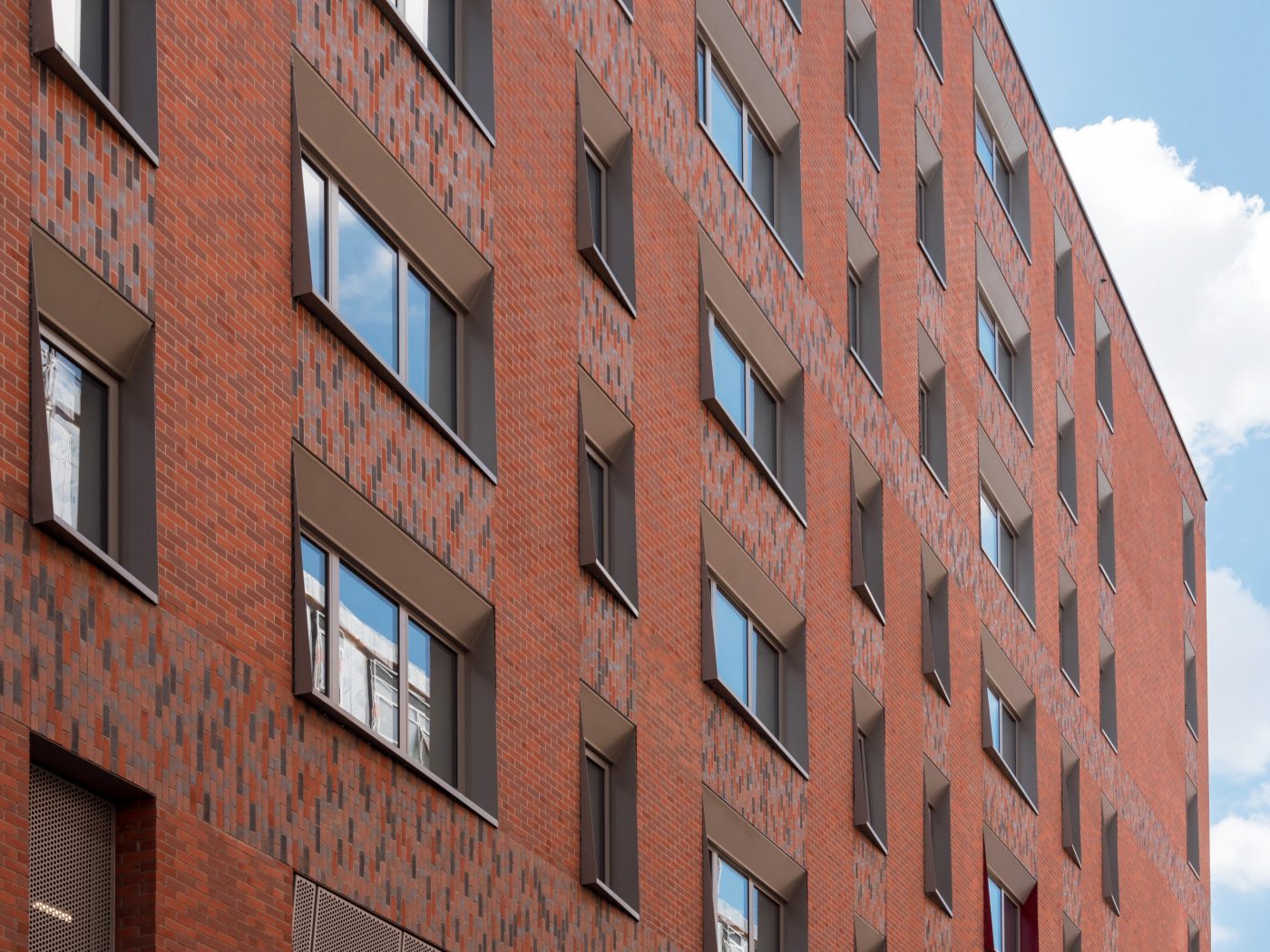 A modern high-rise building with Corium brick facade against blue sky